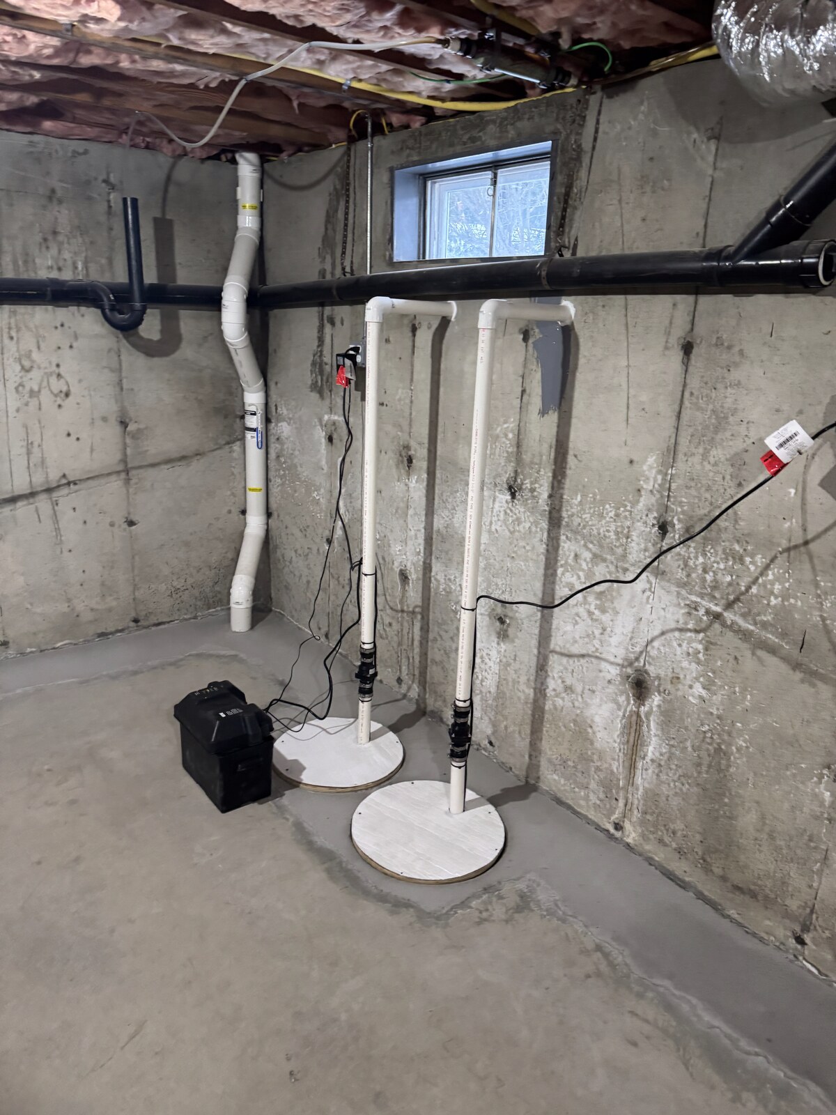 Sump pump installation by A&A Basement Waterproofing — primary sump pump with battery backup and discharge lines in a Connecticut basement